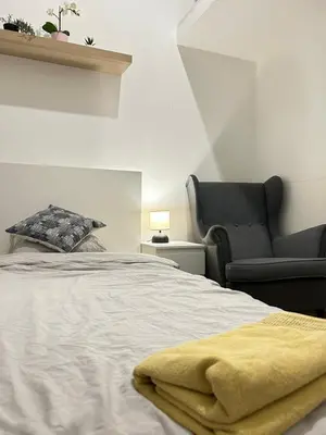a bedroom with a bed and a black chair at Entire unit in the center of Prague in Prague