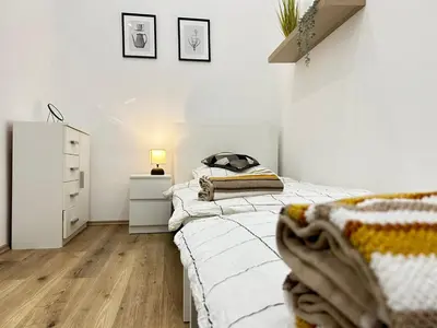 a white bedroom with a bed and a dresser at Entire unit in the center of Prague in Prague