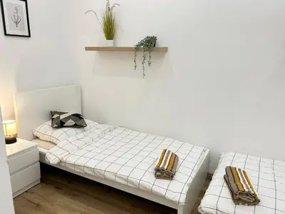 a white room with two beds and a shelf on the wall at Entire unit in the center of Prague in Prague