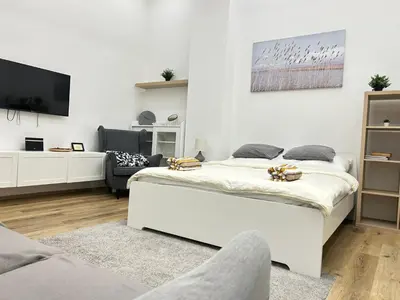 a white bedroom with a bed and a tv at Entire unit in the center of Prague in Prague