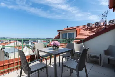 a patio with a table and chairs on a balcony at Encore Boutique Residence by Dwellfort in Prague