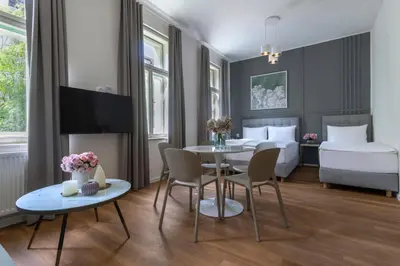 a hotel room with a table and a bedroom at Encore Boutique Residence by Dwellfort in Prague