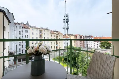 a vase with flowers on a table on a balcony at Encore Boutique Residence by Dwellfort in Prague