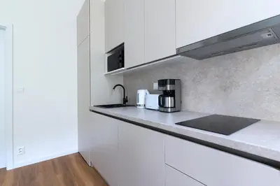 a kitchen with white cabinets and a sink at Encore Boutique Residence by Dwellfort in Prague