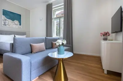 a living room with a blue couch and a table at Encore Boutique Residence by Dwellfort in Prague