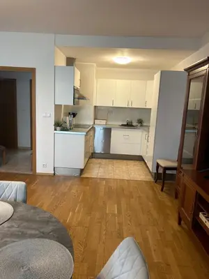 a kitchen with white cabinets and a table in a room at Pegas Apartments in Prague