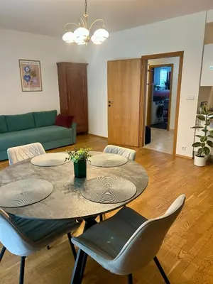 a living room with a table and chairs and a couch at Pegas Apartments in Prague