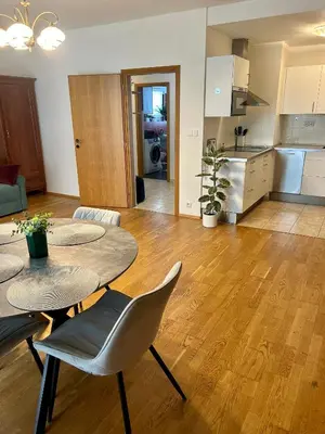 a living room with a table and chairs and a kitchen at Pegas Apartments in Prague
