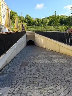a tunnel in a brick road with a fence at PB apartment Prague in Prague