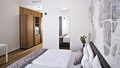 a bedroom with white walls and a bed with flowers on it at Hotel Golden Crown in Prague
