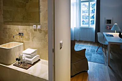 a bathroom with a tub and a sink and a desk at Hotel Golden Crown in Prague