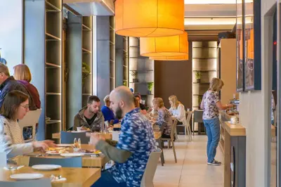 a group of people sitting at tables in a restaurant at Hotel Golden Crown in Prague