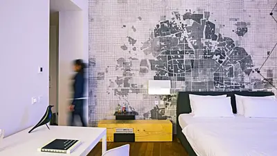 a bedroom with a bed and a wall with a map at Hotel Golden Crown in Prague