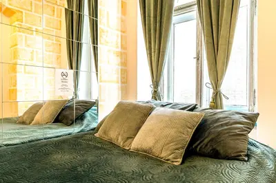 a bed with pillows sitting in front of a window at Wenceslas Palace Stay in Prague