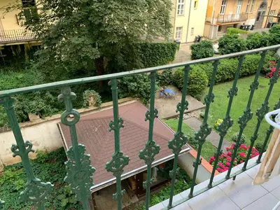 a green fence next to a garden with flowers at Prague Hostel Apartments in Prague