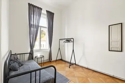a bedroom with a bed and a mirror and a window at Prague Hostel Apartments in Prague
