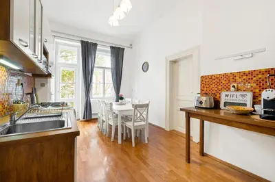 a kitchen with a sink and a table with chairs at Prague Hostel Apartments in Prague