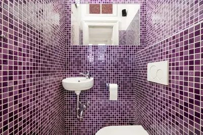 a purple tiled bathroom with a sink and a toilet at Prague Hostel Apartments in Prague