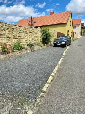 a car parked on the side of a road next to a fence at Chalupa Kokorinsko in Mšeno