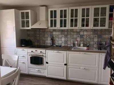 a white kitchen with white cabinets and a sink at Chalupa Kokorinsko in Mšeno