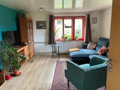 a living room with a blue couch and a table at Chalupa Kokorinsko in Mšeno