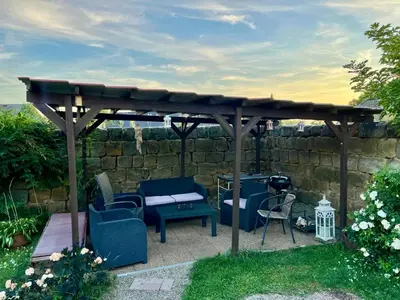 a wooden gazebo with chairs and a table at Chalupa Kokorinsko in Mšeno