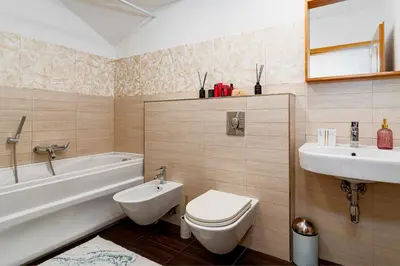 a bathroom with a toilet and a tub and a sink at River Deluxe Suite in Prague