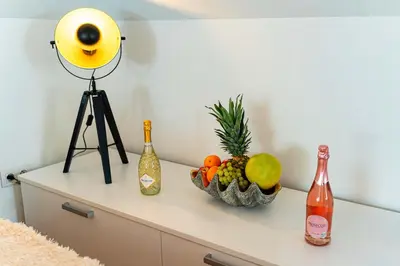 a table with a bowl of fruit and wine bottles at River Deluxe Suite in Prague