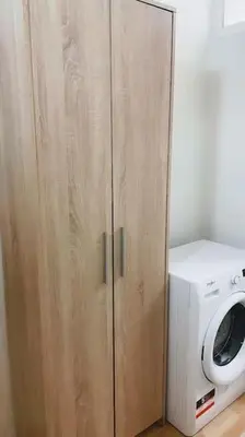a wooden cabinet next to a washing machine at Prague Urban Retreat in Prague