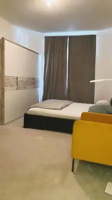 a bedroom with a bed and a window and a yellow chair at Prague Urban Retreat in Prague