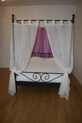 a small bed with a canopy and white curtains at Apartment Marilyn in Prague