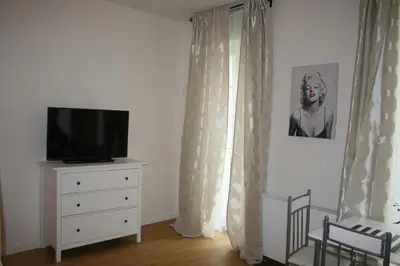 a room with a tv and a dresser with curtains at Apartment Marilyn in Prague