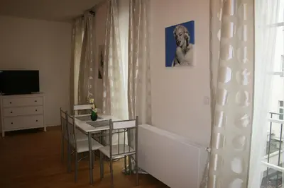 a dining room with a table and chairs and a television at Apartment Marilyn in Prague