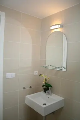 a bathroom with a white sink and a mirror at Apartment Marilyn in Prague