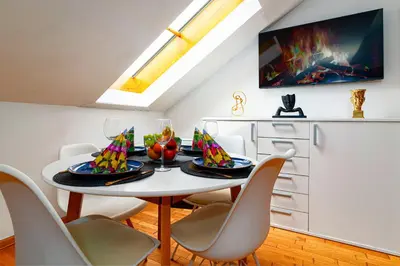 a dining room with a white table and chairs at Golden River Apartment in Prague