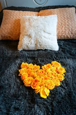 a heart shaped bouquet of orange roses on a blanket at Golden River Apartment in Prague
