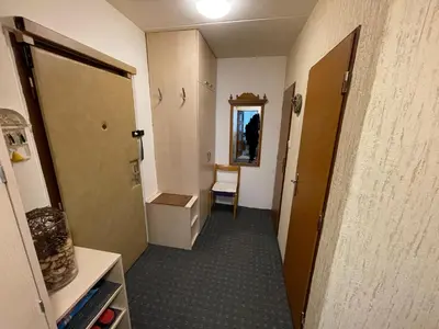 a hallway of a room with a door and a chair at Apartmán Kamýk in Prague