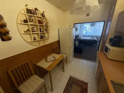 a small kitchen with a table and a refrigerator at Apartmán Kamýk in Prague