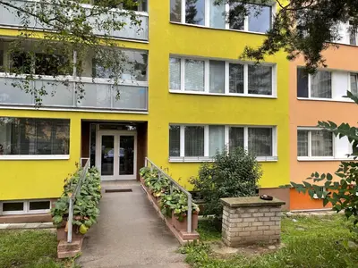 a yellow building with a staircase in front of it at Apartmán Kamýk in Prague