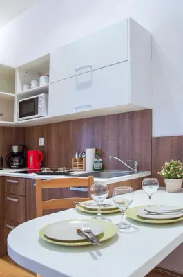 a kitchen with a table with plates and wine glasses at Modern Apartments Opatovická in Prague
