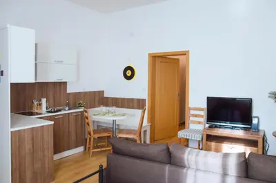 a living room with a couch and a kitchen with a table at Modern Apartments Opatovická in Prague
