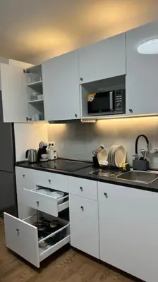 a kitchen with white cabinets and a microwave at Modern apartment in Old town Prague in Prague