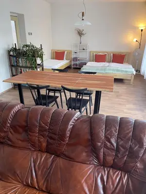 a leather couch in a living room with a table and chairs at Apartment s terasou Lysá in Lysá nad Labem