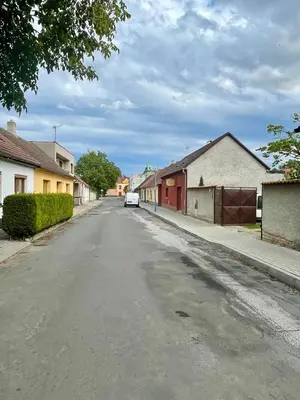 an empty street with a white car parked on the road at Apartment s terasou Lysá in Lysá nad Labem