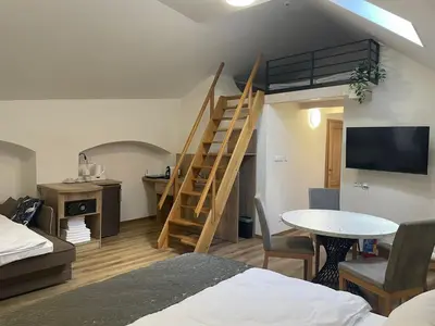 a room with a bed and a staircase and a table at Hotel Karlova Prague in Prague