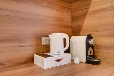 two white coffee makers sitting on a wooden floor at Hotel Karlova Prague in Prague
