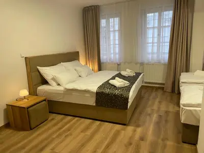 a bedroom with a bed and a table with towels on it at Hotel Karlova Prague in Prague