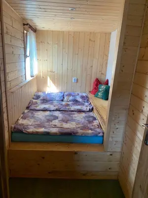 a bed in a wooden room with a bed inside at Chata Mareš in Samechov