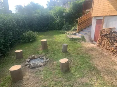 a backyard with logs and a fire pit at Chata Mareš in Samechov
