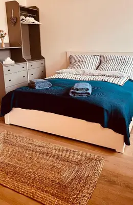 a bedroom with a bed with a blue blanket and a dresser at Četnická Stanice Mšeno in Mšeno
